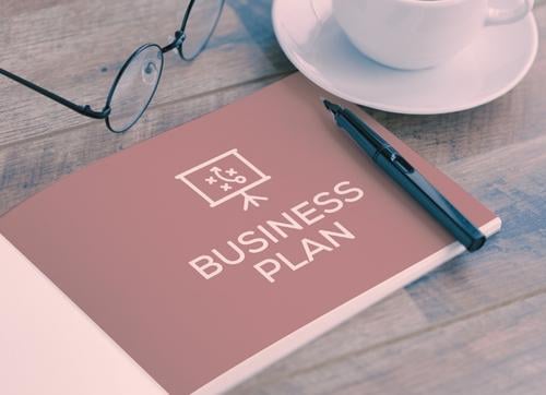 Business plan book, glasses, pen and cup and saucer