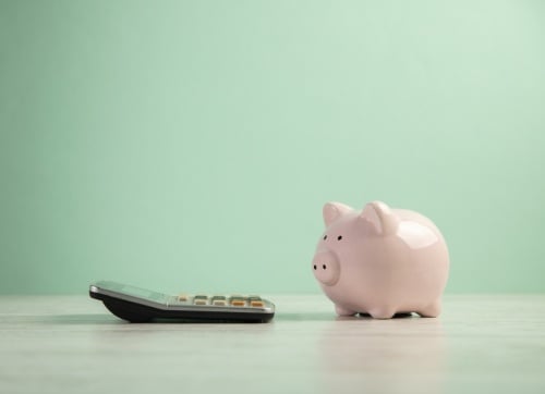 Copy of Retire in Style - lone piggy bank with a calculator with a green background