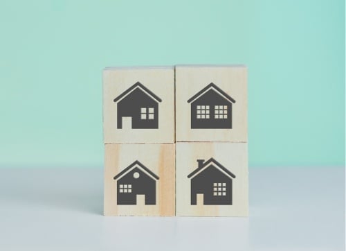 Four blocks stacked in twos with houses stamped on them