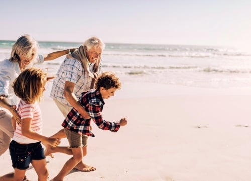 Retire in Style - Grandparents playing with grandkids on the beach