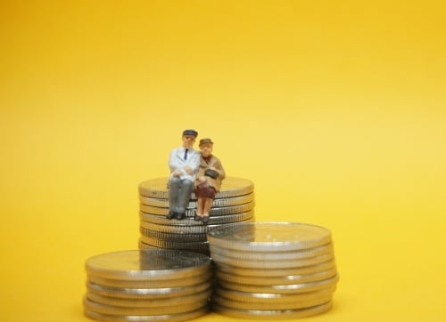 Retire in Style elderly couple figurine sitting on coins with a yellow background