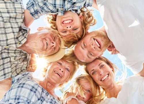 Three generations of family in a circle looking down 