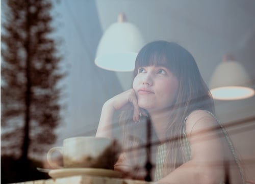 Woman sitting at a cafe thinking