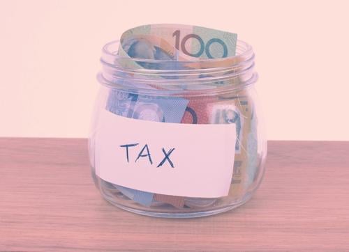 glass jar with tax on a sticker and  Australian dollar notes 