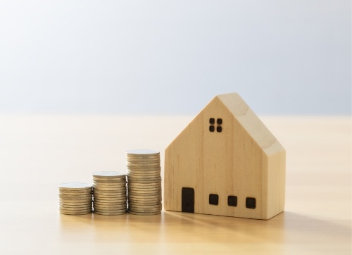 timber block house and three piles of coins