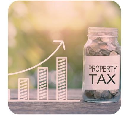 jar full of coins with Property tax on white label sitting in timber with a computer 3  bar graph image with an arrow pointing up as the graph gets higher