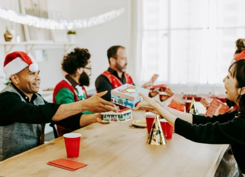 Work Christmas party with gift exchange amongst staff sitting at a table