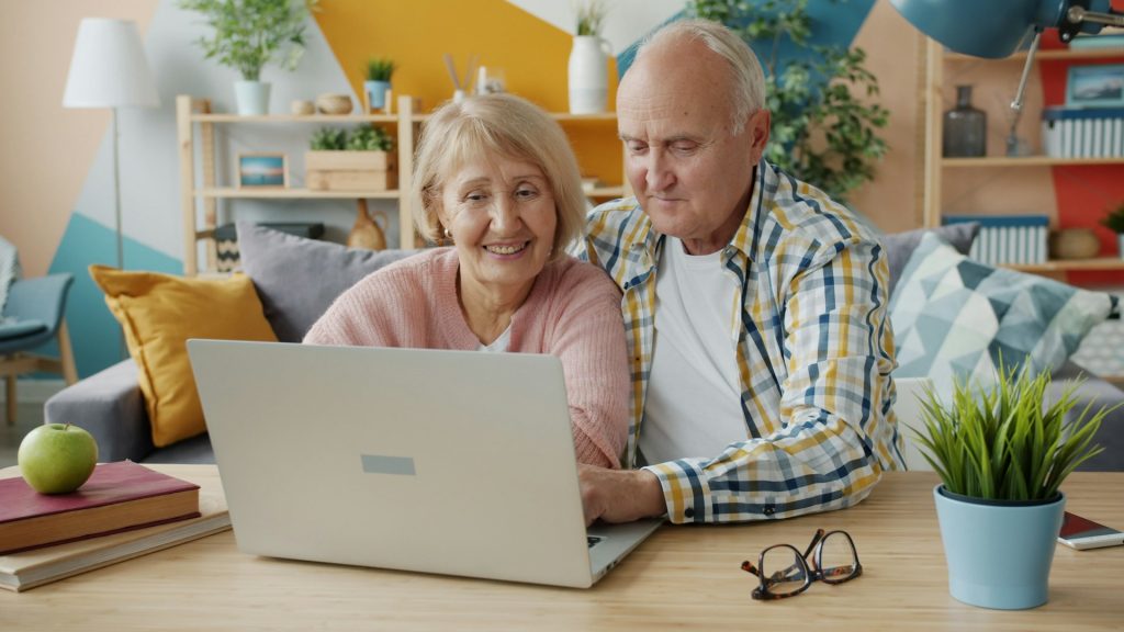 Senior couple planning their retirement together on a laptop at home