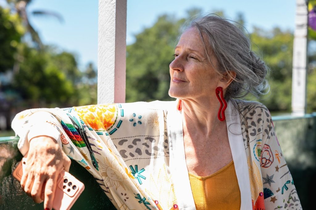 Older woman sitting outside looking into the distance