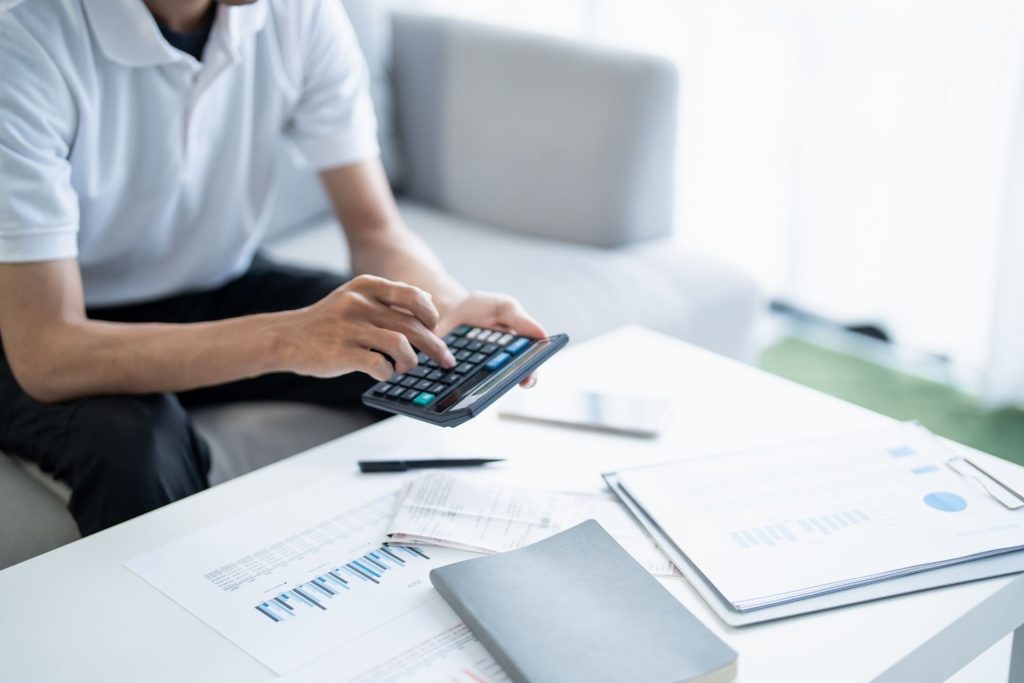 Man working out tax implication on a calculator